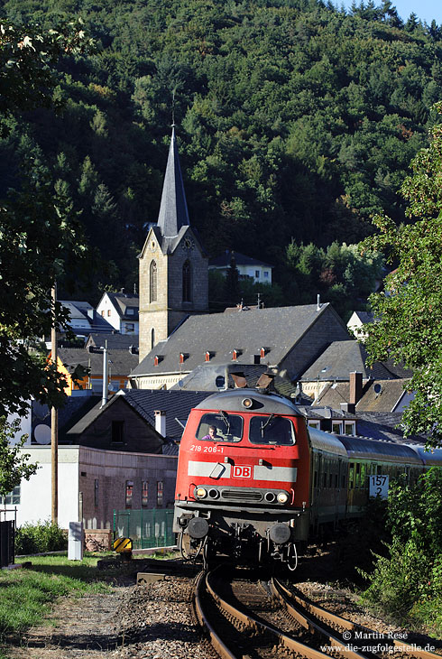 Mit dem RE 12085 fährt die 218 206 in Kordel ein. Im Hintergrund ist die St. Amandus-Kirche zu sehen. 31.8.2009