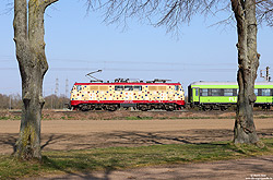 … einen Monat später wurden noch bunte Punkte angebracht, was der Lok den Name „Masern-Lok“ bescherte. Am 25.3.2023 fährt die 111 057 bei Brühl in Richtung Köln.