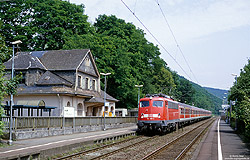 110 399 mit verkehrsrote n-Wagen auf der Siegstrecke am Haltepunkt Dattenfeld mit Bahnhofsgebäude
