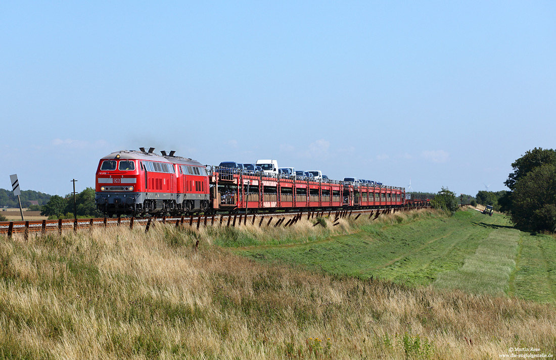 Abschlepplokomotive 218 838 in verkehrsrot mit SyltShuttle bei Klanxbüll auf der Marschbahn