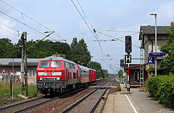 Abschlepplokomotive 218 835 in verkehrsrot mit Hilfsgerätewagen am Haltepunkt Glaubitz
