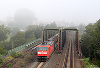 Herbstanfang im Haunetal. Mit einem Güterzug in Richtung Süden hat die 152 031 soeben den Bahnhof von Bad Hersfeld passiert und überquert nun die Fulda, 23.9.2010. An Herbsttagen gehört der Nebel hier schon zum „guten Ton“ …