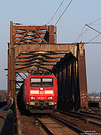 Im abendlichen Licht des 8.3.2011 poltert die 185 002 mit einem Güterzug bei Duisburg Hochfeld Süd über die Rheinbrücke. 8.3.2011.