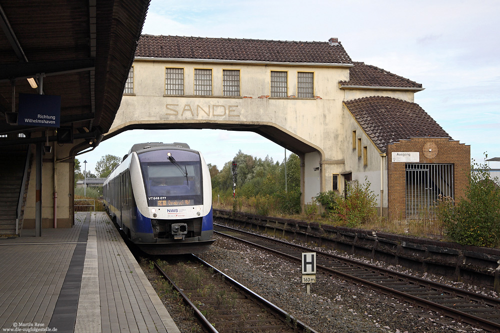 Die inzwischen ungenutzte Bahnsteigüberführung von Sande verfällt zunehmend und wird der Elektrifizierung der Strecke sicherlich weichen müssen. Am 28.9.2016 habe ich hier den VT648 077 in Szene gesetzt.


