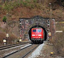 Bis zum Schwarzkopftunnel werden schwere Güterzüge nachgeschoben. Die Schiebelok kehrt dann Lz zurück nach Laufach. Oberhalb des Tunnelportals kann man das Baujahr in römischen Ziffern (1854) erkennen. Neben dem aufwändigen Schiebebetrieb war die notwendige Sanierung des über 160 Jahre alten Tunnels der Grund für den Neubau der Strecke.