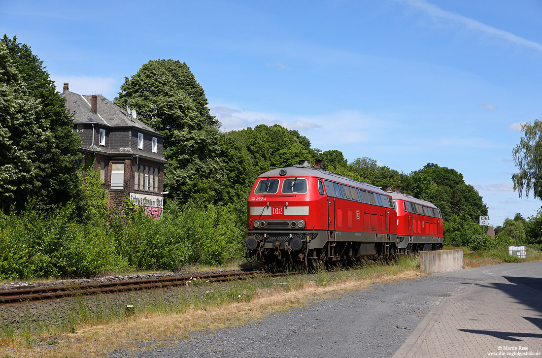 218 832 im Bahnhof Schwerte Ost mit Empfangsgebäude im Wald versteckt