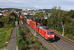 verkehrsrote 185 012 überquert mit einem Containerzug die Fuldabrücke in Bad Hersfeld