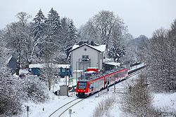 620 046 als RE nach Trier im Schnee im Bahnhof Schmidtheim mit Bahnhofsgebäude auf der Eifelstrecke