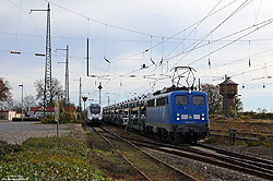 blaue 140 042 der PRESS alias 140 834 mit Autozug neben Wasserturm im Bahnhof Lutherstadt Eisleben