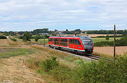 Wie auf vielen fränkischen Nebenbahnen dominieren die Triebwagen der Baureihe 642 auch auf der Strecke Neustadt (Aisch) – Steinach – Rothenburg ob der Tauber. Bei Burgbernheim dieselt der 642 116 am 13.7.2022 als RB56671 durch die Felder nach Neustadt.