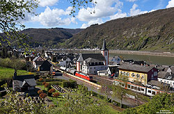 152 046 mit Güterzug in Kestert auf der rechten Rheinstrecke mit Bahnhof und Kirchen St.Georg