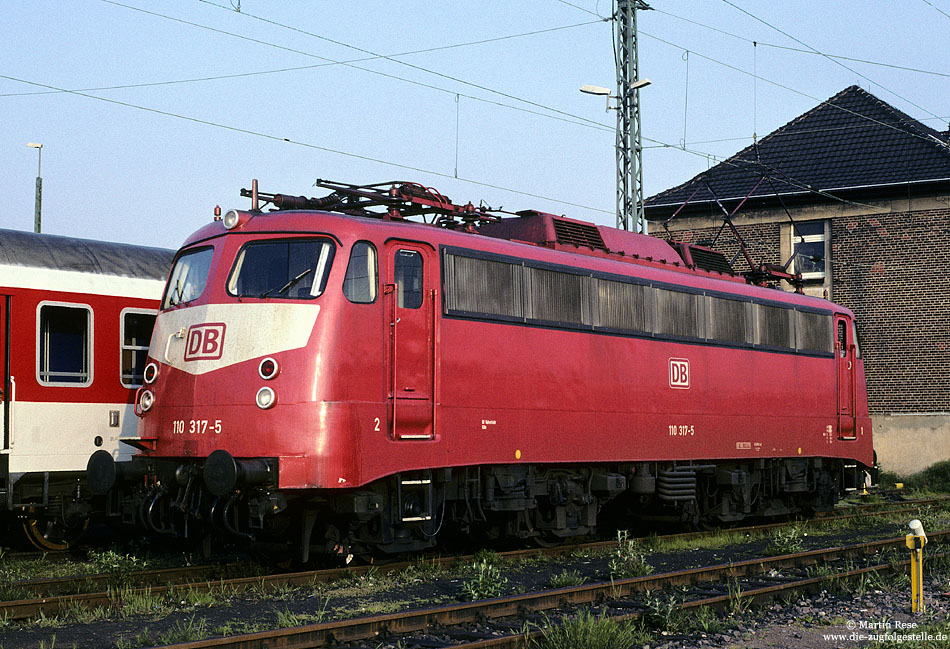 110 317 in orientrot im Bahnhof Köln Bbf