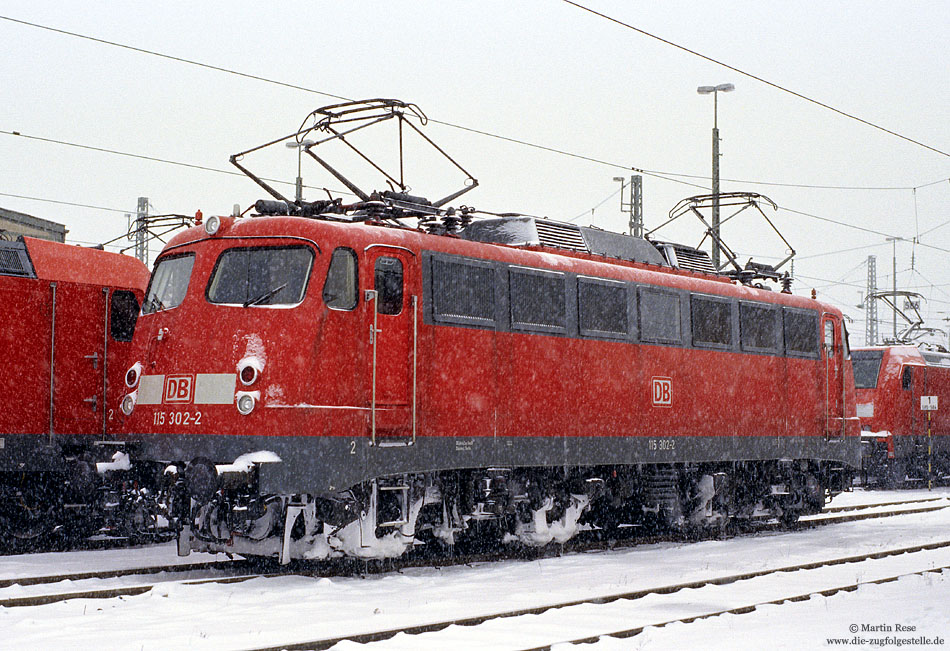 115 302 ex 110 302 in verkehrsrot im Bahnhof Stuttgart Bbf im Schnee
