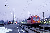 110 196 in orientrot im Bahnhof Rosenheim im Winter