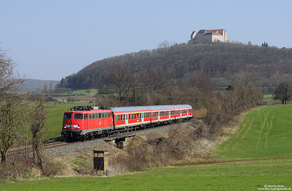 Mit der RB37160 (Donauwörth - Aalen) ist die Stuttgarter 110 483 zwischen Lauchheim und Westerhausen unterwegs, 2.4.2009. Im Hintergrund tront die Kapfenburg.