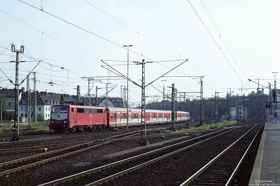 Bis Mitte der 90er Jahre bildete die Baureihe 111 das Rückrad des
S-Bahnverkehrs an Rhein und Ruhr. Bis Ende 1995 wurden diese Lokomotiven vom S-Bahndienst abgezogen, da sie für die Bespannung der Doppelstockzüge benötigt wurden. Mitte 1998 mussten einige Loks dieser Baureihe aber noch einmal auf der S-Bahn aushelfen:Nach dem schweren ICE-Unfall in Eschede mussten kurzfristig alle Achsen der ICE ausgetauscht werden. Dadurch kam es zu Lieferschwierigkeiten bei den Achsen für die Baureihe 143, sodass einige Lokomotiven vorübergehend abgestellt werden mussten. Als Ersatz kamen Dortmunder 111 zum Einsatz. 111 144 mit einer S11 nach Düsseldorf Wehrhahn, fotografiert am 3.8.1998 in Düsseldorf Hbf.
