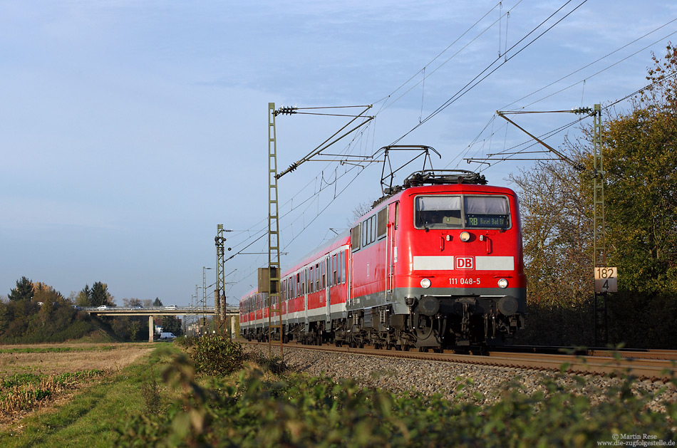 Im abendlichen Licht des 31.10.2014 fährt die Freiburger 111 048 mit der aus Offenburg kommenden RB26575 bei Kenzingen nach Basel Bad. Bf.