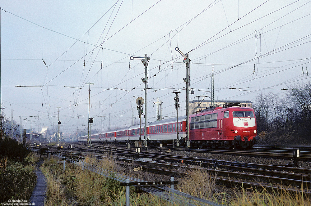 Mit dem über die rechte Rheinstrecke umgeleiteten EC109 durchfährt die Frankfurter 103 144 den Bahnhof Porz (Rhein). Bis zum Bau der Schnellfahrstrecke Köln-Rhein/Main, präsentierte sich der Bahnhof noch mit alter Stellwerkstechnik. 22.11.1997
