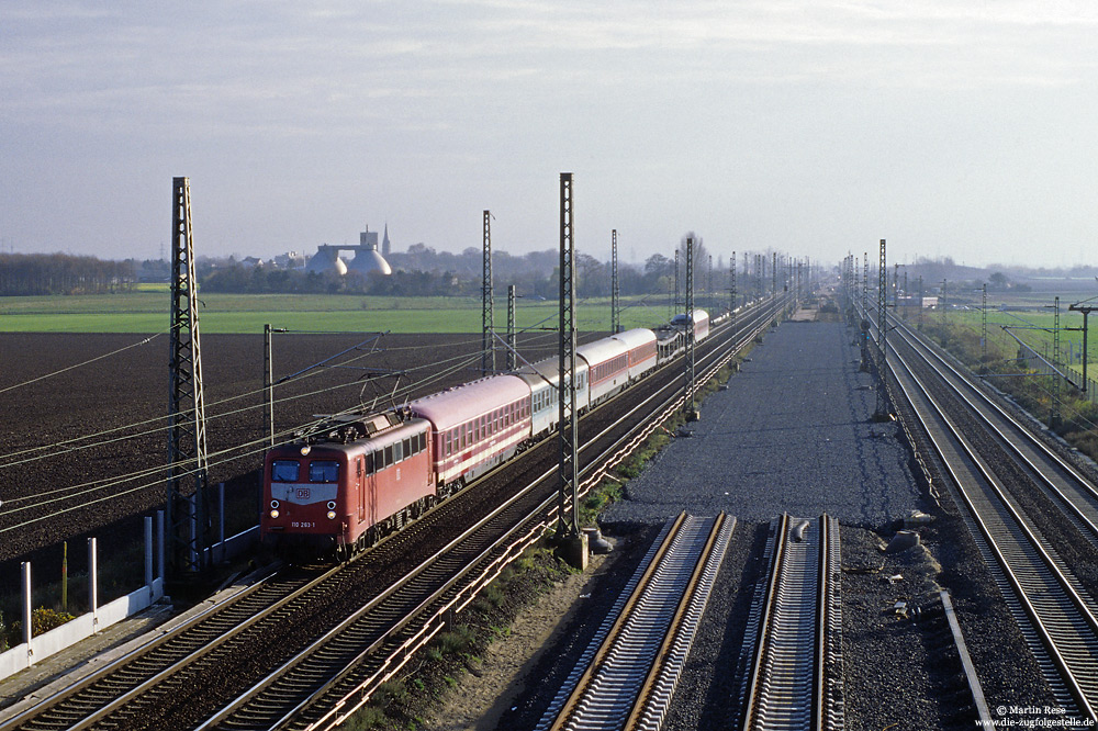 Für den Bau der Schnellfahrstrecke Köln Rhein/Main wurden die Güterzuggleise zwischen Porz und Troisdorf westlich verschwenkt. Am 30.11.2000 war die Schnellfahrstrecke noch im Bau, als die Kölner 110 263 mit dem bunt gemischten Pbz 69340 (Ludwigshafen – Köln Deutzerfeld) auf der Reisezugstrecke gen Norden fährt.
