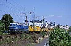 Hinter der V232-SP-040 verbirgt sich die ehemalige 242 002 der DB. Am 1.8.2003 durchfährt die Lok mit einem langen Bauzug die "Drosselgassenstadt" Rüdesheim.