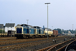  drei Lokomotiven in ozeanblau/beige mit einem Containerwagen im Bahnhof Paderborn Nord Zuglok ist 211 077  