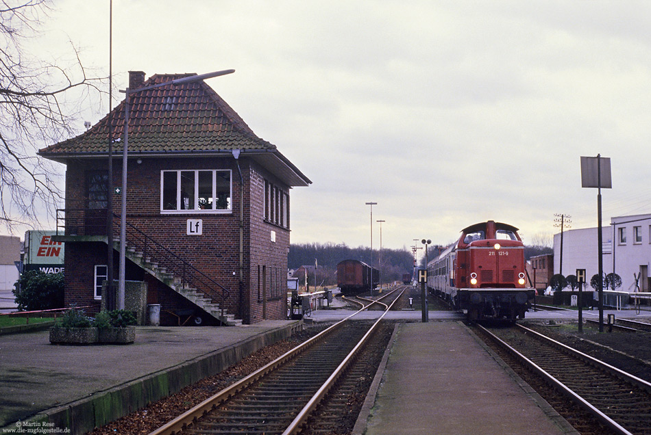 Mit dem N8337 (Osnabrück – Delmenhorst) fährt die Osnabrücker 211 121 in Lohne ein, 4.2.1988. Die Lok war erst wenige Wochen zuvor vom Bw Gießen nach Osnabrück gekommen.
