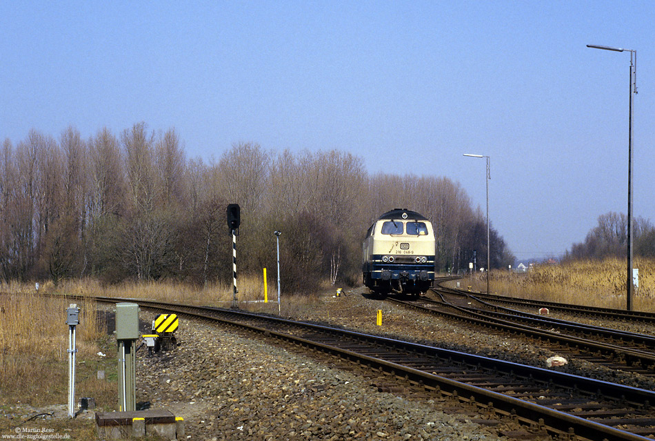 Aus Wilhelmshaven kommend habe ich die Oldenburger 216 048 als Lz bei der Einfahrt in Sande fotografiert. Im Vordergrund ist die Strecke nach Esens zu sehen. 7.4.1987