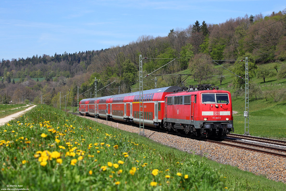 111 091 mit dem RE19423 nach Aalen mit Löwenzahn auf der Wiese bei Lorch