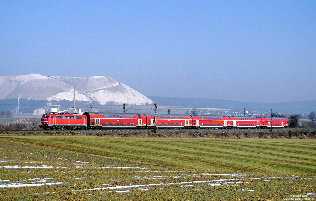Vor der Kulisse der Abraumhalde des Kaliwerks in Neuhof zieht die Frankfurter 111 194 den Regionalexpress aus Fulda nach Frankfurt/Main Hbf