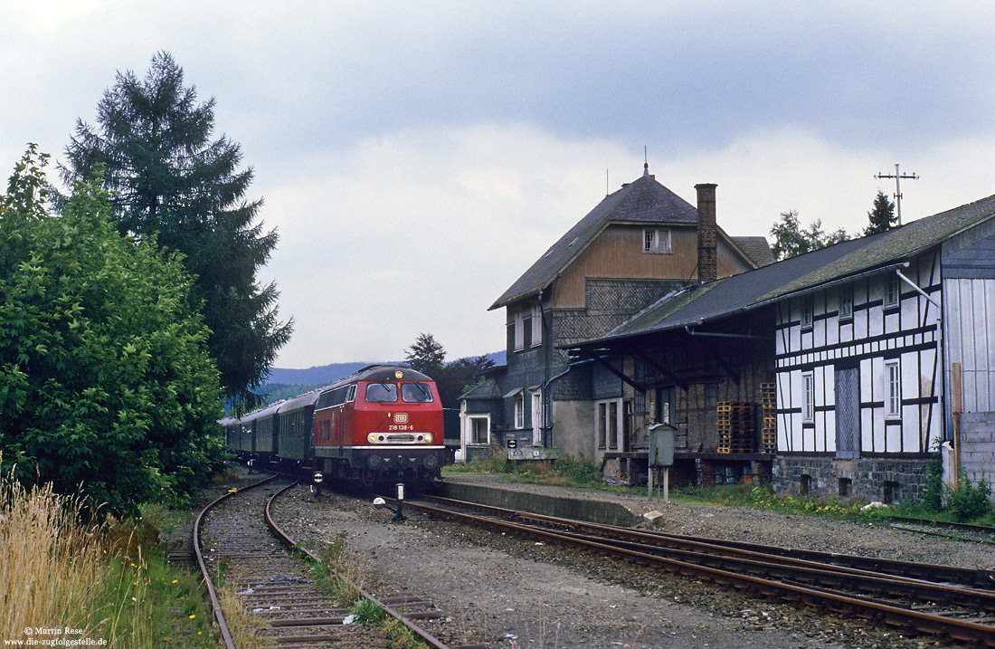 218 138 in rot mit Sonderzug im Bahnhof Gleidorf