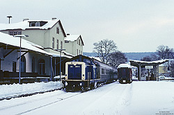 212 309 in ozeanblau beige mit Nahverkehrszug im Bahnhof Olpe mit Bahnhofsgebäude im Schnee