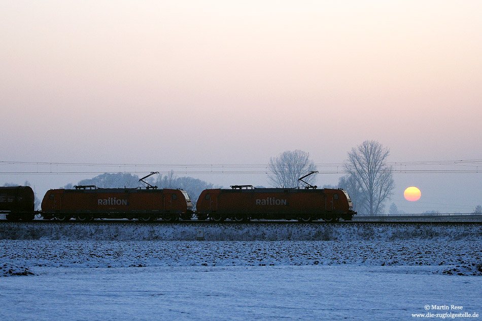 Das nun wirklich letzte Sonnenfoto des 12.1.2009:  Aus Ingolstadt kommend fährt eine 185-Doppeltraktion mit einem Kesselwagenzug bei Donauwörth dem Sonnenuntergang entgegen.