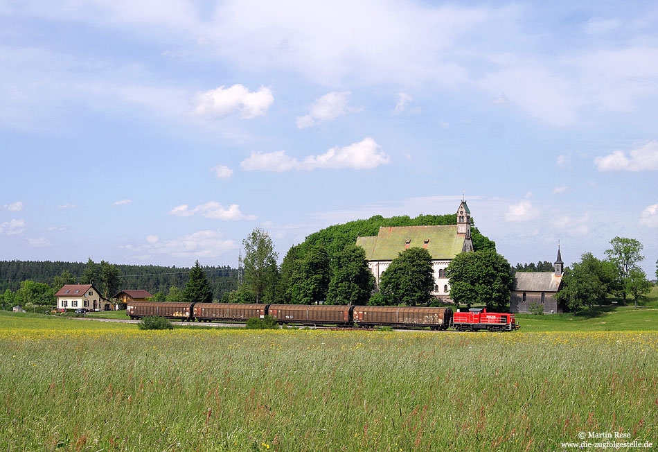 Dreimal in der Woche wird die Papierfabrik in Neustadt bedient. Am 5.6.2009 befand sich die 294 629 mit dem FZT 55838 schon auf dem Rückweg nach Villingen, als sie nahe Löffingen die Wallfahrtskirche zum Witterschneekreuz passiert.