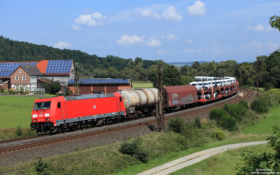 Nachdem die Dächer des Örtchens Herrmannspiegel mit Solarzellen „verziert“ wurden, hat das bekannte Motiv viel vom einstigen Reiz verloren. Dennoch lässt sich der Zugverkehr hier noch immer in Szene setzen. Mit einem gemischten Güterzug fährt die 185 319 gen Süden. 8.8.2014