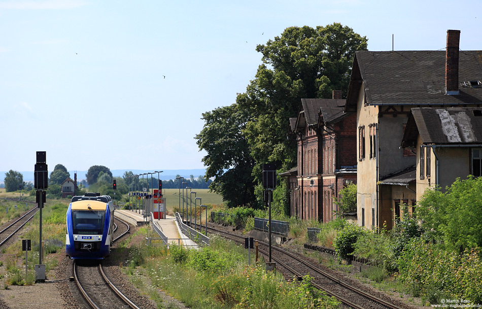 Auf dem Weg von Thale nach Magdeburg verlässt der HEX80341 den Abzweigbahnhof Wegeleben, 6.7.2014. Mit der Umstellung auf ESTW-Technik wurde der Bahnhof auf drei Gleise zurück gebaut. Das ehemalige Empfangsgebäude und die beiden Stellwerke sind seither dem Verfall preisgegeben.