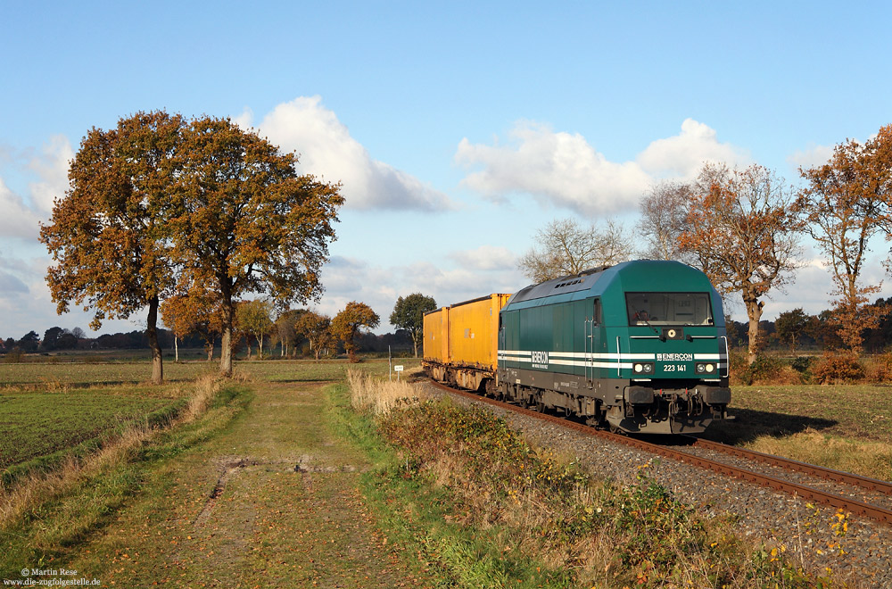 Im gemächlichem Tempo rollt die Enercon-223 141 mit einem Containerzug über das Anschlussgleis vom Industriegebiet Aurich Nord (wo sich u.a. auch das Enercon-Werk befindet) nach Abelitz. Lange Zeit lag die Strecke im Dornröschenschlaf und wurde vor wenigen Jahren reaktiviert - allerdings aus Kostengründen nur als