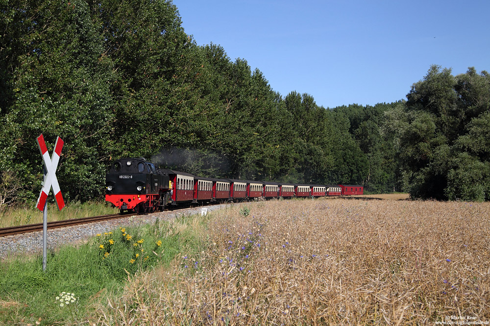 Zwischen Heiligendamm und dem Haltepunkt Steilküste rollt die 99 2322 mit dem MBB14628 durch die Felder gen Kühlungsborn, 26.7.2016.