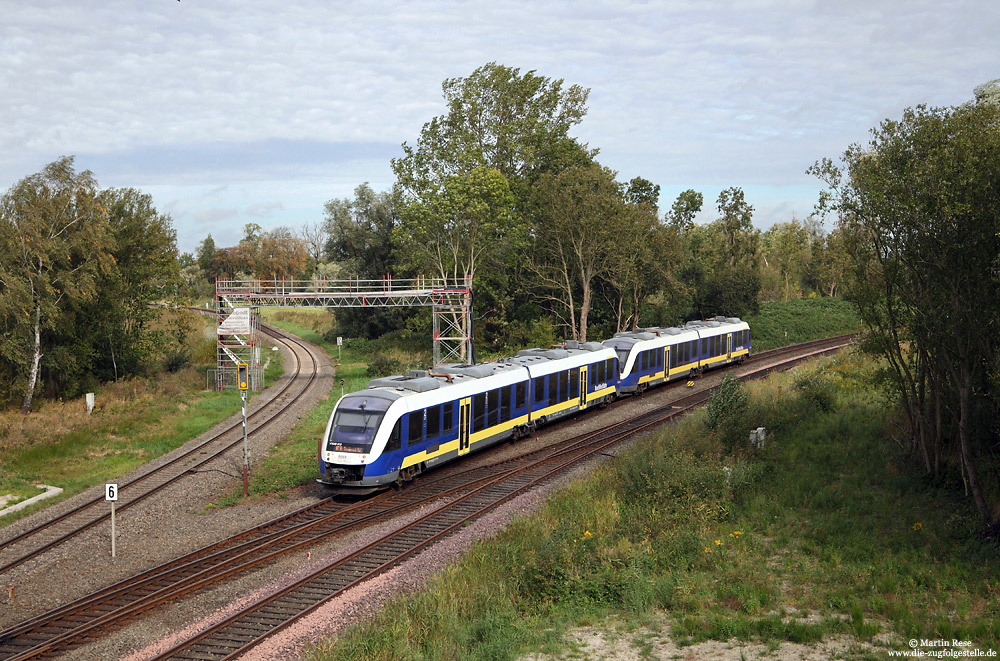 Im letzten Jahr wurde nördlich des Bahnhofs Sande eine Straßenbrücke errichtet, die neue Motive an den Strecken nach Wilhelmshaven und Esens bietet. Aus Wilhelmshaven kommend fährt NWB82314 in Sande ein. 28.9.2016
