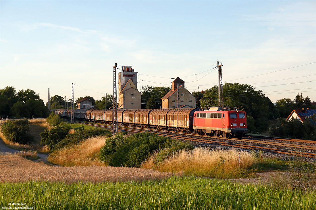 Mit einer satten Verspätung von zwei Stunden fährt die 140 432 der BayernBahn mit dem Henkelzug DGS59945 (Düsseldorf Reißholz – Gunzenhausen) im letzten Licht des 12.7.2022 durch den Bahnhof Herrnberchtheim.
