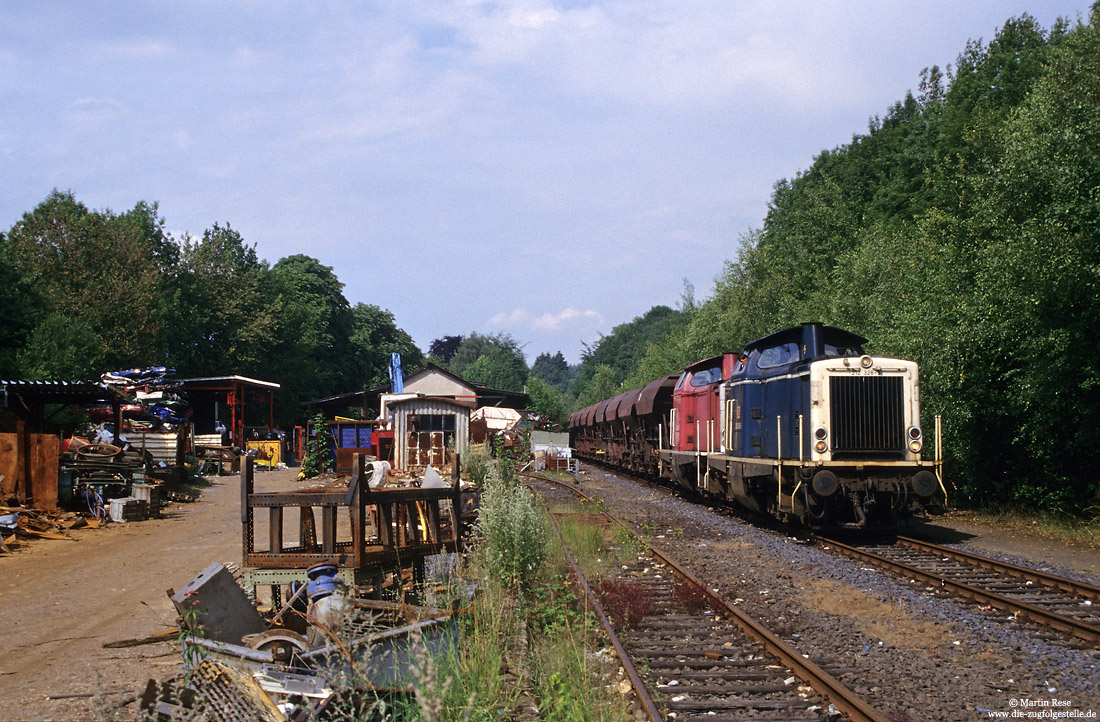 212 328 mit Schotterzug im Bahnhof Kotthausen neben Schrottplatz