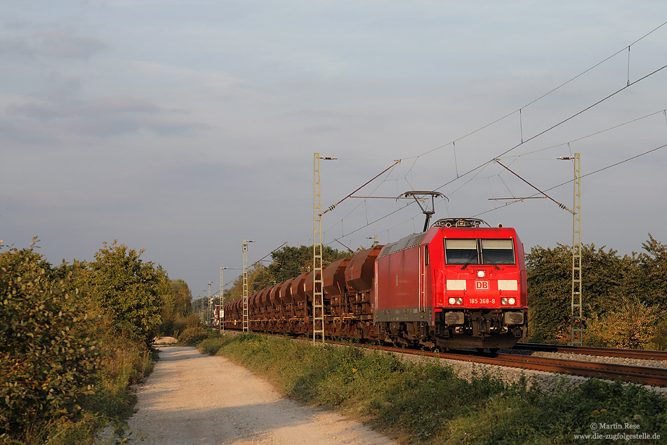 Im letzten Sonnenlicht fährt die 185 368 mit einem Ganzzug bei Forchheim in Richtung Süden
